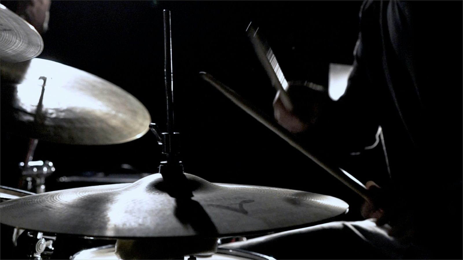 Drummer speelt op bekkens in een donkere oefenruimte